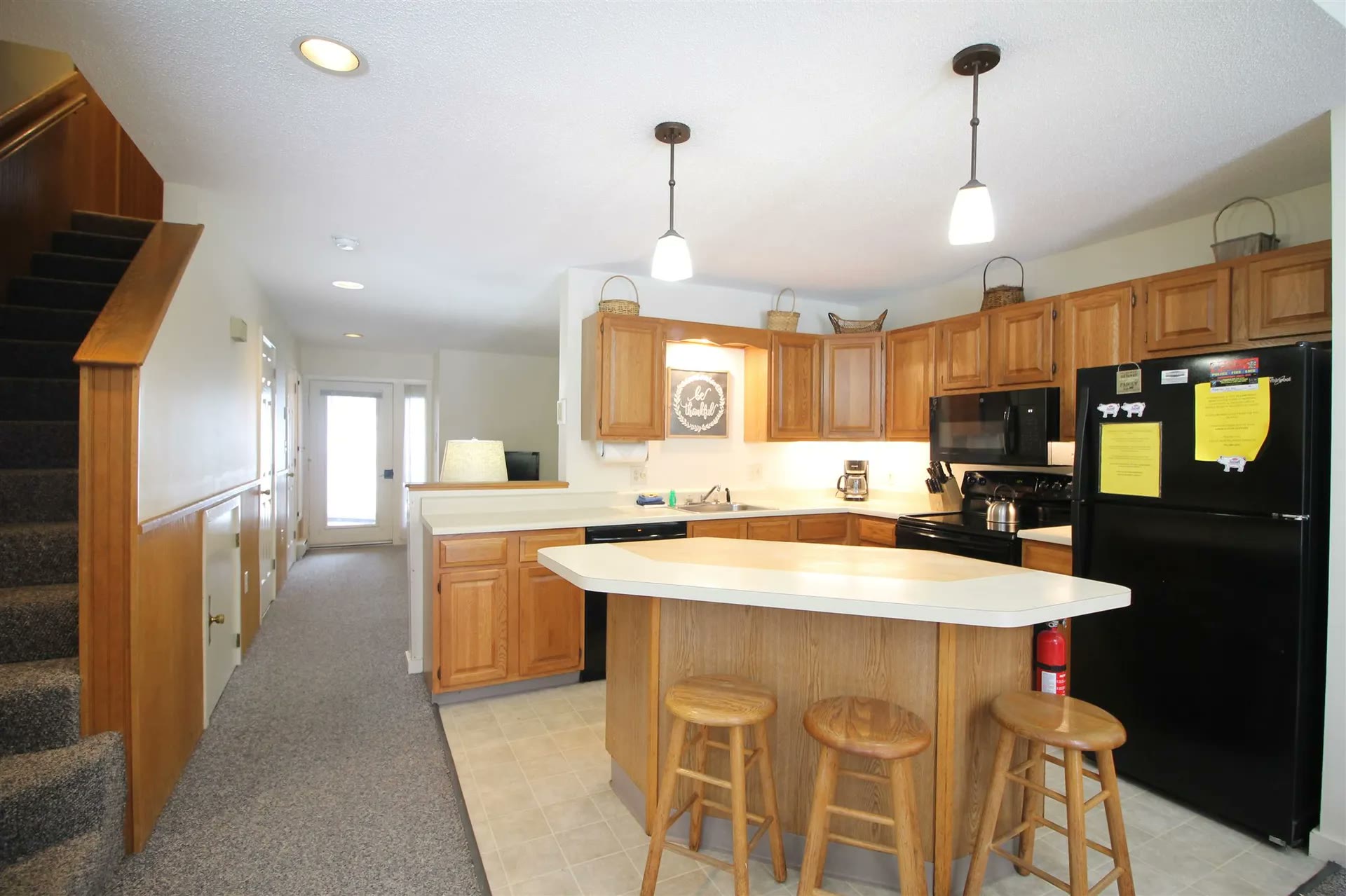 Kitchen with island seating, oak cabinets and black appliances
